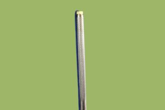 An Amish Stainless Steel Fishing Spear 7-tine on a green background.
