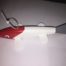 A red and white toy fish on a white surface.