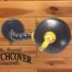 The original Catch Cover Rattlesnake Reel - MFRSR-01 on a wooden wall.