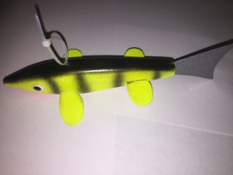 A yellow and black plastic fish toy on a white surface.