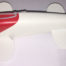 A white and red toy fish made out of paper.