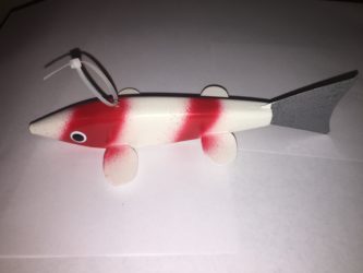 A red and white koi fish on a white surface.