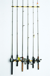 Four Du-Bro 'Track a Rod' Rod Holders hanging on a white wall.