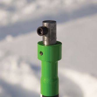 A green Ion Quick Release Adapter Additional Stub Shaft 22035 with a metal handle in the snow.