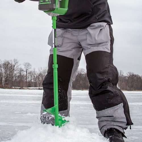 A man holding a green Ion Extensions shovel on the ice.