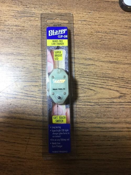 A small package of a Nature Vision Blazer CLIP-ON Hands Free LED Lure Charger sitting on a table.