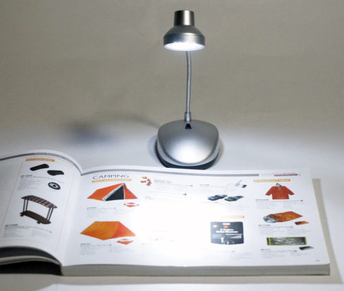 An open book with a 14 LED Table Lamp FL347 Batteries Included on it.