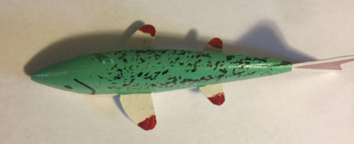 A green and red 6-1/2 Inch Lamont Mounsdon Wood Spearing Decoys toy on a white surface.