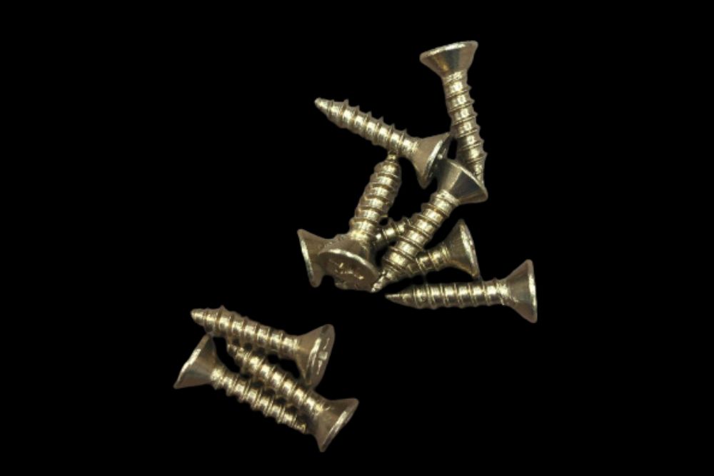 A group of Catch Cover Ice Hole Cover Wood Screws #8 x 3/4 Brass or Black on a black background.