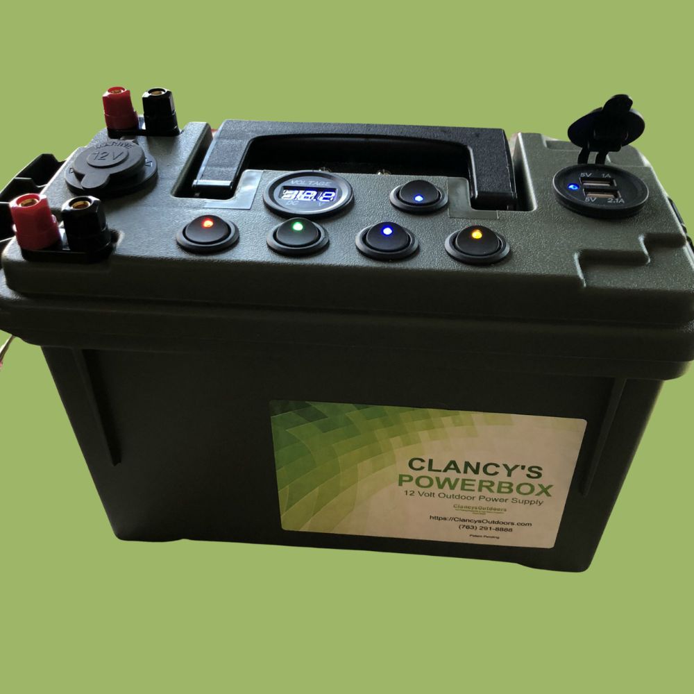 Clancy's PowerBox 12-volt power supply USB Cigarette Plug Jig Glow Cup on a green background.