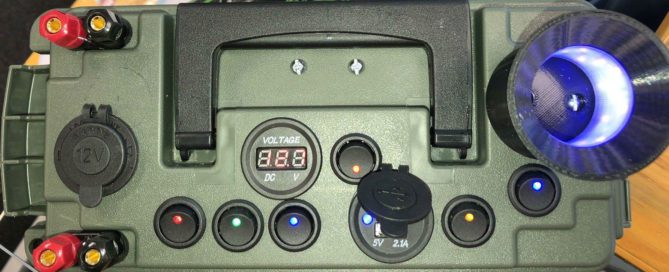 Clancy's PowerBox 12-volt power supply USB Cigarette Plug Jig Glow Cup, a small electronic device with a blue light on it.