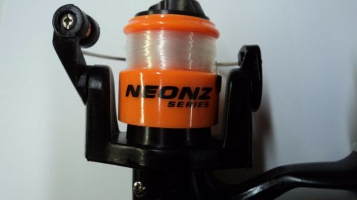 A fishing reel with the HT Neon Ice Combo Assortment on it.