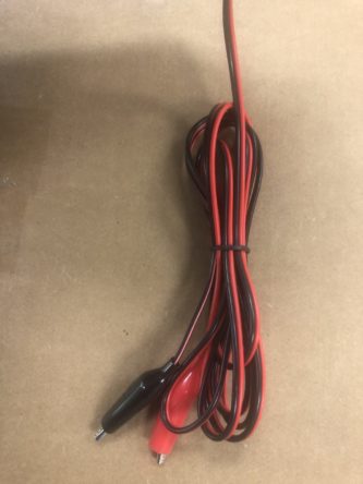 A red and black wire on a table.