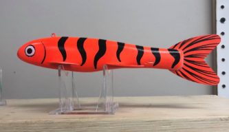 A GDOT toy tiger fish sitting on top of a stand.
