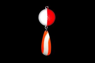 An NCS-033 Northern Crack Spearing Teaser Orange and White fishing lure hanging on a black background.