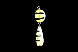 A NCS-035 Northern Crack Spearing Teaser Le Le (black, yellow, white) pendant hanging on a black background.
