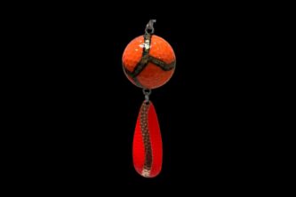 An NCS-010 Northern Crack Spearing Teaser Orange with Gold Lines pendant hanging on a black background.