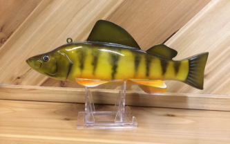 A yellow and black plastic Yellow Perch, WRYP on a stand.