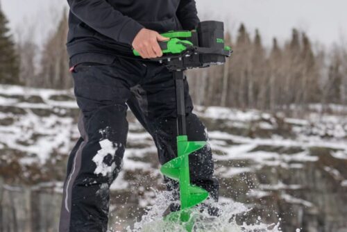 A man is using an ION® ALPHA PLUS 8" or 10" 40V Li Ion Ice Auger Poly in the snow.