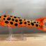An orange and black fish on a clear stand, Goodin 9" frog decoy.