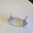 small silver metal bracket on paper